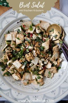 a white plate topped with tofu and vegetables next to chopsticks on a table