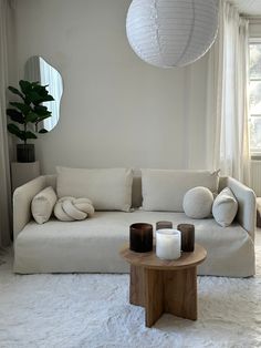 a living room filled with white furniture and pillows