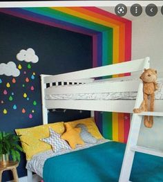 a child's bedroom with rainbow painted on the wall and white bunk bed frame