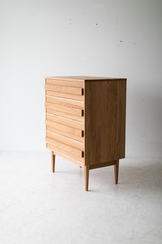 a wooden dresser sitting on top of a white floor