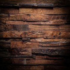 wood planks are stacked up against the wall in this dark room, and it looks like they have been made from different types of wood