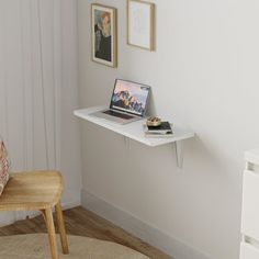 a laptop computer sitting on top of a white shelf