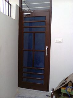 a brown door sitting next to a white wall with a window on top of it