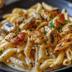 pasta with mushrooms and parmesan cheese on a black plate, ready to be eaten