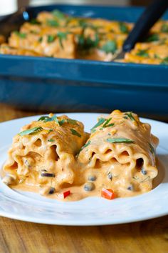 two tortilla shells covered in cheese sauce on a white plate