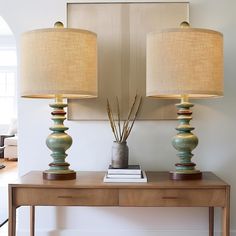 two lamps sitting on top of a wooden table