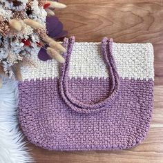 a crocheted bag sitting on top of a wooden floor next to a plant