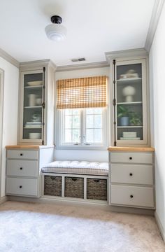 an empty room with white walls and drawers