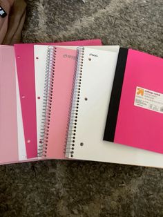 three spiral bound notebooks with pink and white covers