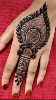 a henna tattoo on someone's hand that is decorated with black and white designs