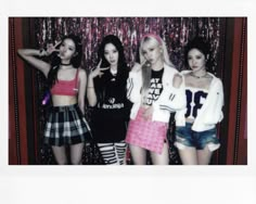 four girls posing in front of a wall with sequins and tinsel on it