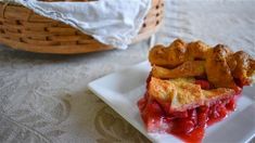 a slice of strawberry pie on a plate with a basket in the backgroud