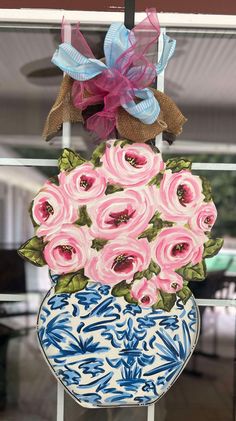 a blue and white vase filled with pink flowers