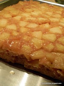 a piece of bread with apples on it sitting on top of a counter next to a pan