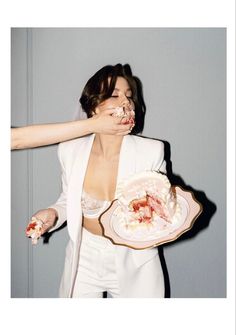 a woman is holding a plate with food on it and her hands are covering her mouth