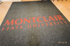 an area rug with the words montclar state university written in red on it