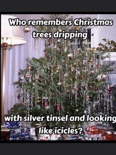 a christmas tree with silver tinsel and looking like it's being blown off