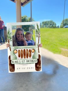 a woman holding up a card with a photo of a child in the back of a jeep