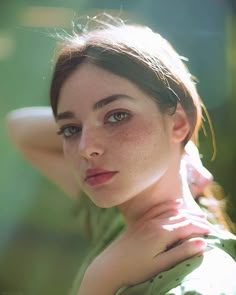 a woman with freckled hair and blue eyes posing for a photo in the sun