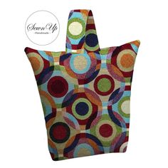 a handbag with colorful circles on the front and side, in multi - colored fabric