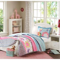 a child's bedroom with pink, blue and white bedding