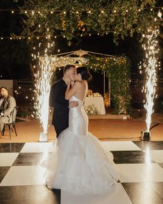 a bride and groom kissing on the dance floor