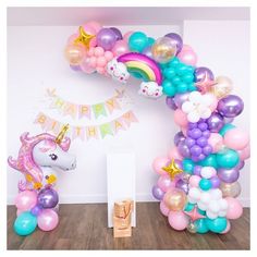 a unicorn balloon arch with balloons and streamers