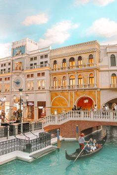 a gondola in the middle of a canal with people on it and buildings around