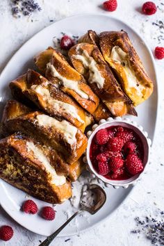 a white plate topped with french toast and raspberries