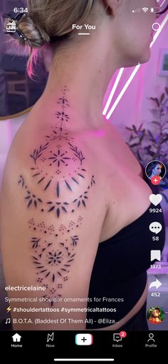 the back of a woman's shoulder with an intricate tattoo design on her chest