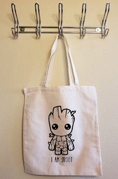 a tote bag hanging on a wall with the words i am groot printed on it