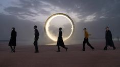 several people walking in front of a circular object