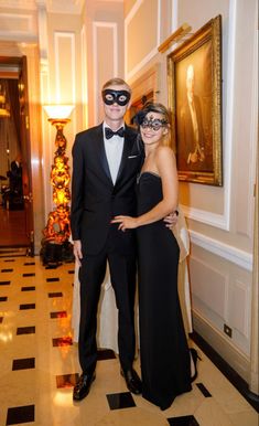 a man and woman wearing masks pose for a photo