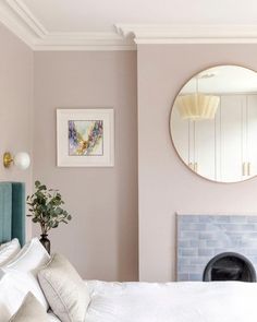 a bedroom with a bed, mirror and fireplace in the corner on the wall above it