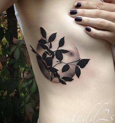 a woman's stomach with a black and white flower tattoo on her left side