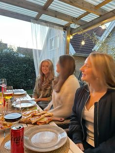 four people sitting at a table with food and drinks