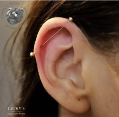 a woman's ear with two piercings on it