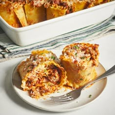 a white plate topped with lasagna covered in cheese