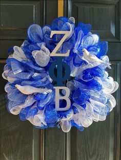 a blue and white mesh wreath with the letter z is for boo on it's front door