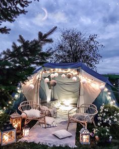 an outdoor tent is lit up with fairy lights