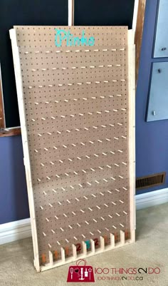 a peg board with pins on it in front of a blue wall