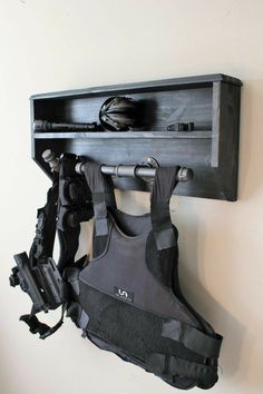 a wall mounted shelf with scuba gear hanging on it's sides and an umbrella holder