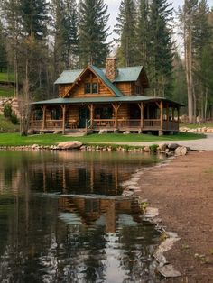 a log cabin sits on the shore of a lake