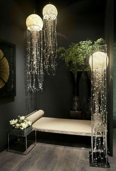 a living room with black walls and chandeliers hanging from it's ceiling