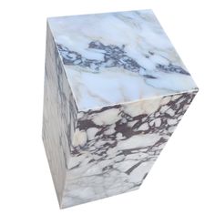 a white and brown marble block on a white background