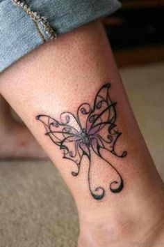 a woman's foot with a butterfly tattoo on the side of her leg,