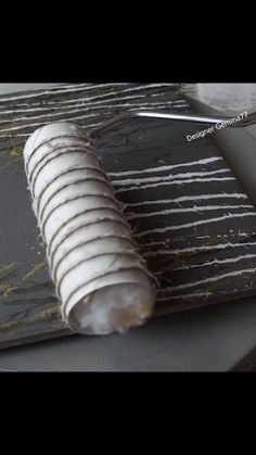 a knife is laying on top of some black and white marbled papers that have been cut in half