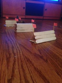 several popsicle sticks sitting on top of a hard wood floor next to a tv