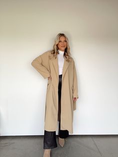 Experience elevated sophistication with this exclusive, lightweight trench coat. Featuring a collared neckline, waist tie detail, and wrap detail, this piece will be the perfect transition piece for any look. Whether you’re business-savvy shopping, dinner and drinks, or simply working from home, this luxe trench coat will be with you every step of the way. Its soft comfort and versatile style make it both trend-forward and timeless. 97% Polyester 3% Spandex Hand wash cold. Fall Beige Outerwear With Tie Waist, Chic Collared Outerwear For Work, Chic Collared Belted Outerwear, Chic Belted Collared Outerwear, Chic Long Belted Outerwear, Trendy Belted Outerwear For Work, Belted Long Sleeve Outerwear For Business Casual, Belted Long Coat For Work, Belted Notch Lapel Outerwear For Business Casual