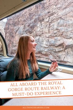 a woman sitting at a table with a glass of wine in her hand and the words all aboard the royal gorge route railway a must do experience